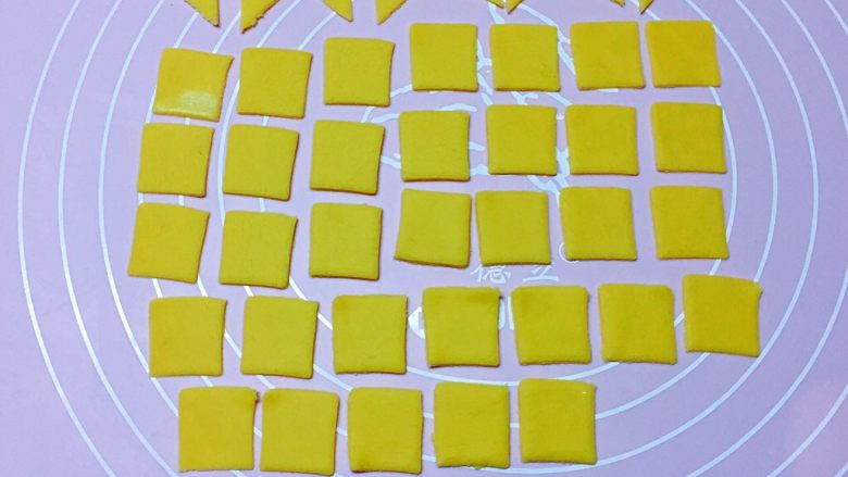 幸运福,再取黄色面团擀开，用小正方形模具压出36个小正方形，然后将12个从中间一切为二，变成24个小三角形。