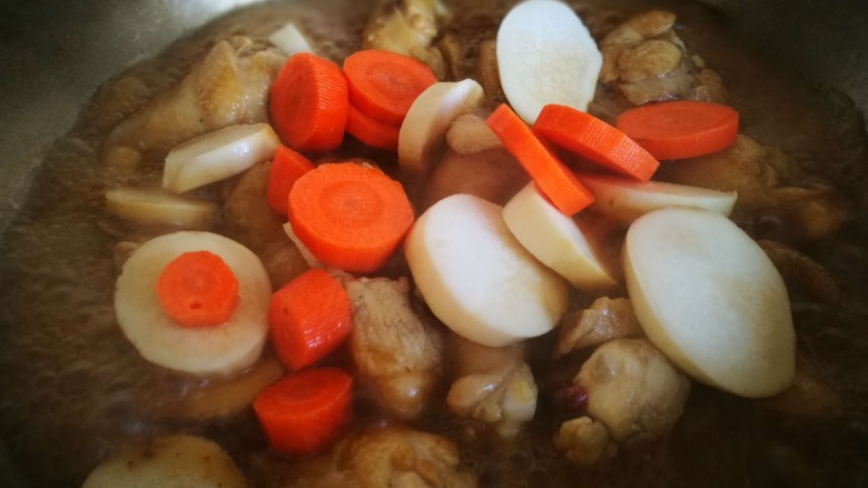 红烧杏鲍菇鸡翅根,倒入杏鲍菇和胡萝卜 盖上锅盖焖煮
