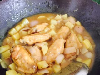 咖喱鸡翅,锅中放油，下洋葱，煸炒出香味，加入土豆，翻炒片刻。加入清水没过食材，加入鸡翅，转中小火煮十几分钟。