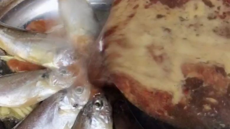 干锅黄花鱼,将调料汤汁倒入摆好鱼的锅中