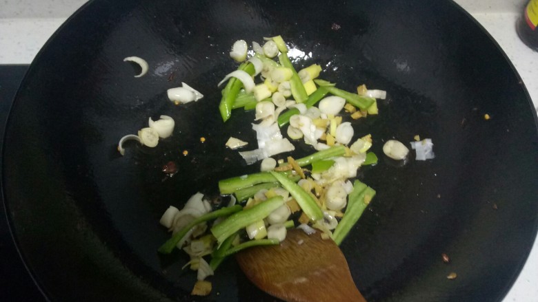 鸭血炒平菇,锅中放入适量油，炒香姜末、葱末，放入青椒丝翻炒均匀。