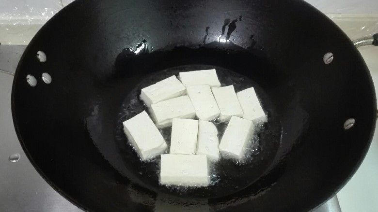 葱香红椒老豆腐,热锅热油，放老豆腐下锅中火煎