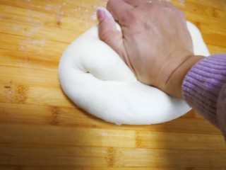 萌萌哒-小猪豆沙包,取出面团用手在撒干粉的面板上反复揉压排气，不断的揉压，多揉一段时间，这样蒸出的馒头才会光滑。