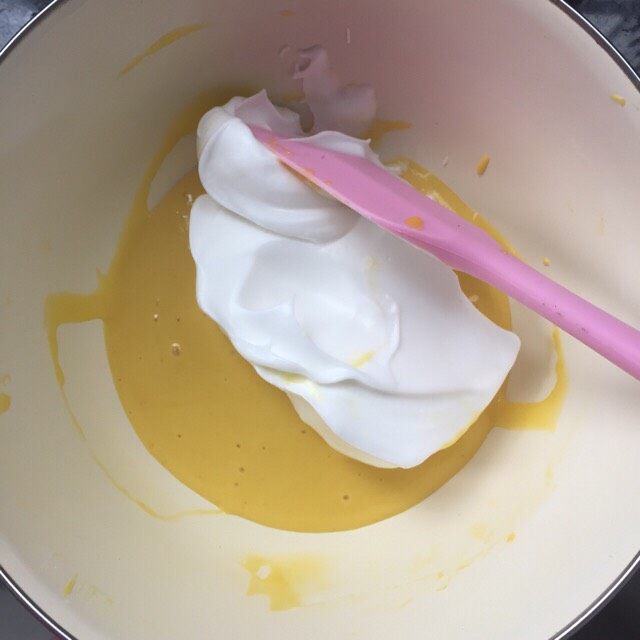 超级松软的戚风蛋糕（六寸）,取三分之一蛋白放入蛋黄糊中拌均匀
