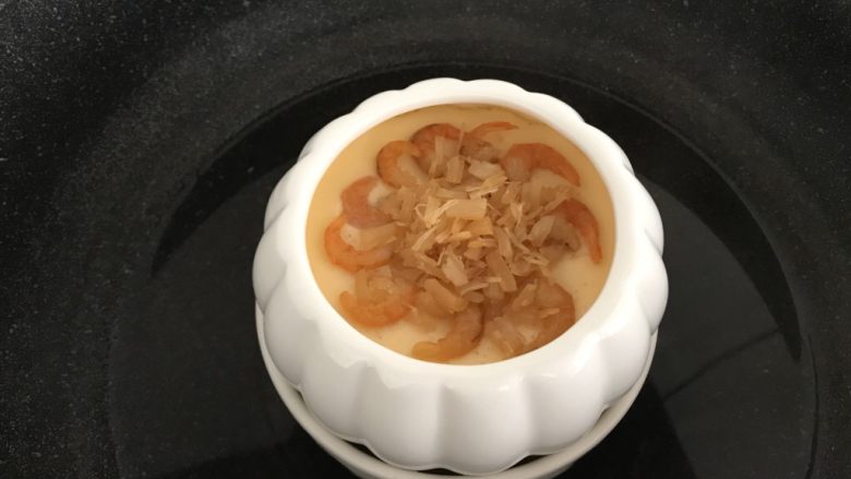 瑶柱虾米蒸水蛋,蒸至约5分钟，蛋液表面凝固时把炒香的瑶柱虾米放在上面，再盖上盖子蒸约10分钟
