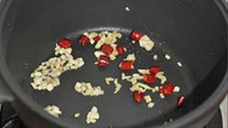 牙签牛肉,小锅中的油倒出，只留一点点。把姜蒜末爆香后倒入干辣椒爆香。