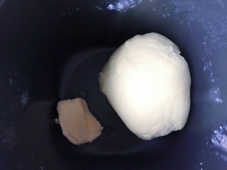 蘑菇小面包,开启和面程序，揉至面团拓展阶段，加入黄油，继续开启和面程序。