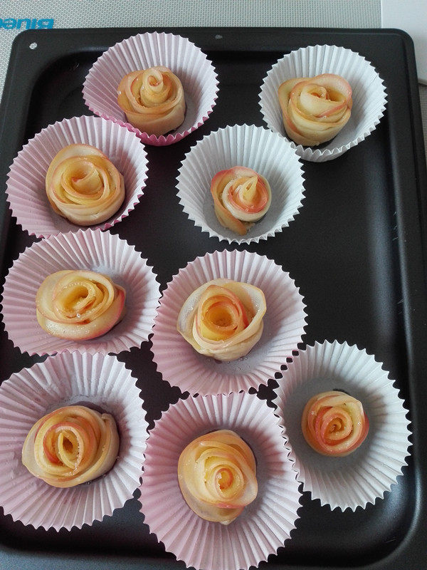 苹果玫瑰花,做好的花朵放入纸膜中，放在烤盘里