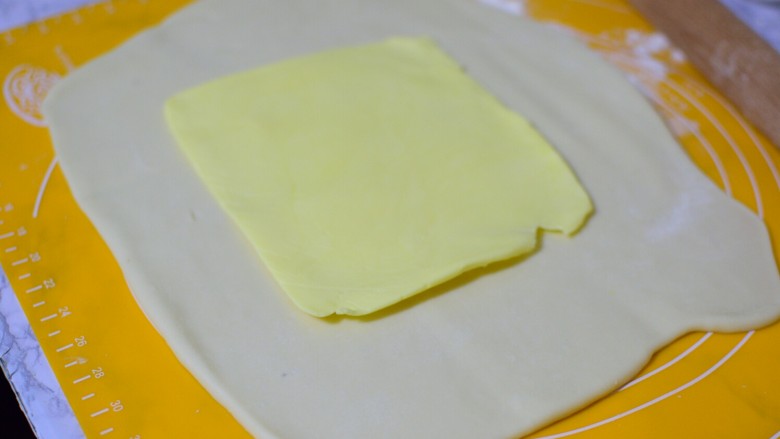 可颂牛角包,面团擀成方形，把冷藏的黄油片放中间