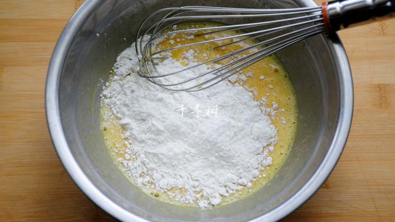 香浓蛋奶黄金豆,将低筋粉筛入或直接倒入搅匀的蛋液中，用蛋抽呈Z字形或无规则方向搅动。