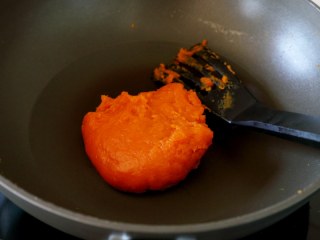 微波炉美食+地瓜糯米糍,先将地瓜与糖和玉米淀粉拌拌，使其没有粉颗粒，然后开火炒，炒到这样粘稠状态。
