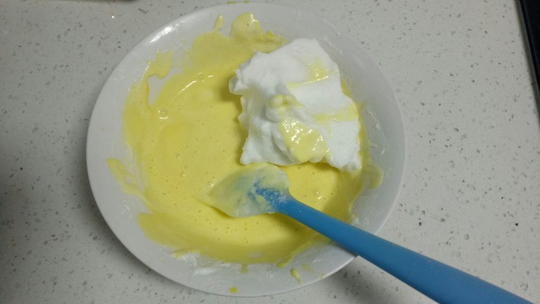 不加糖的蛋糕,蛋黄糊中加入1/3蛋清，用翻拌的手法搅拌均匀。
