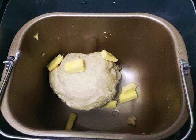 新疆果仁大列巴,启动揉面20分钟后，放入软化的黄油继续揉面25分钟，然后放在温暖的地方发酵至2倍大。