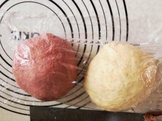 新疆果仁大列巴,把面团均匀的分成两份，其中一份我加了一点红曲粉。揉圆后放置30分钟醒面。