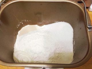 新疆果仁大列巴,面包机里放入除了黄油，核桃仁，葡萄干，蔓越莓干外的所有材料。酵母，糖，盐，淡奶油分别放在面包桶内的四个角落。
