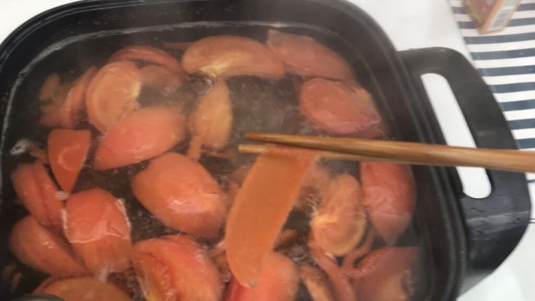 番茄炖牛腩,用筷子夹住番茄皮，皮很容易就从番茄上脱落下来。接着盖住锅盖煮十分钟左右