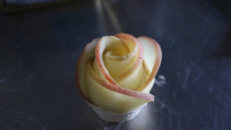 苹果玫瑰花,从一头开始卷起来，最后收口时压进。记得整一下形状哈，
烤箱180度预热10分钟