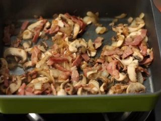 蘑菇培根蛋卷,3. 少许油炒香洋葱，加入培根炒出油脂，加入蘑菇和盐，黑胡椒调味。蘑菇软化即可。 
