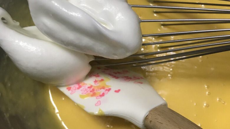 简单制作两款彩绘蛋糕卷~UKOEO 风炉制作,取一刮刀蛋白霜加入蛋黄糊，用打蛋器无规则拌均匀，搅拌同时用刮刀辅助。