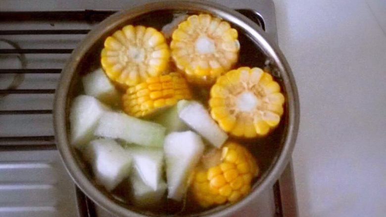 冬瓜玉米排骨汤,锅中水开后，放入玉米、冬瓜。小火炖1个半小时左右，炖到食材软烂全家就可以享用了。