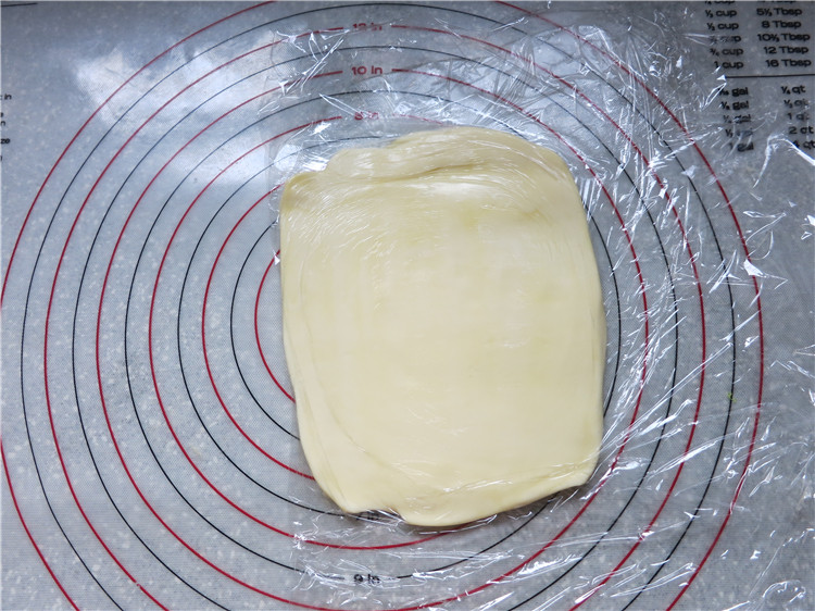 颜值不重要关键是味道--网红脏脏包,将145克片状黄油包在保鲜膜里，先用擀面杖上下左右敲打几下，然后擀成长方形，大小正好可以包入面团中即可，擀好的黄油要与面团软硬度一致