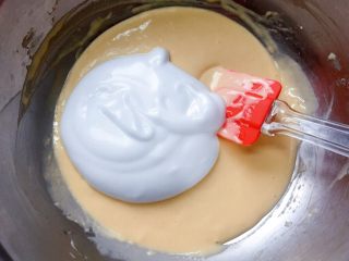 牛奶鸡蛋饼,将三分之一蛋白霜加入到蛋黄糊中，切拌均匀。