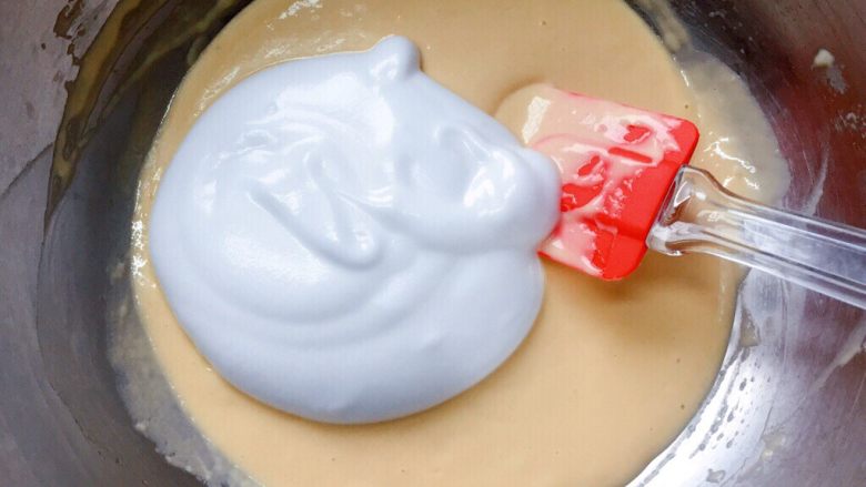 牛奶鸡蛋饼,将三分之一蛋白霜加入到蛋黄糊中，切拌均匀。
