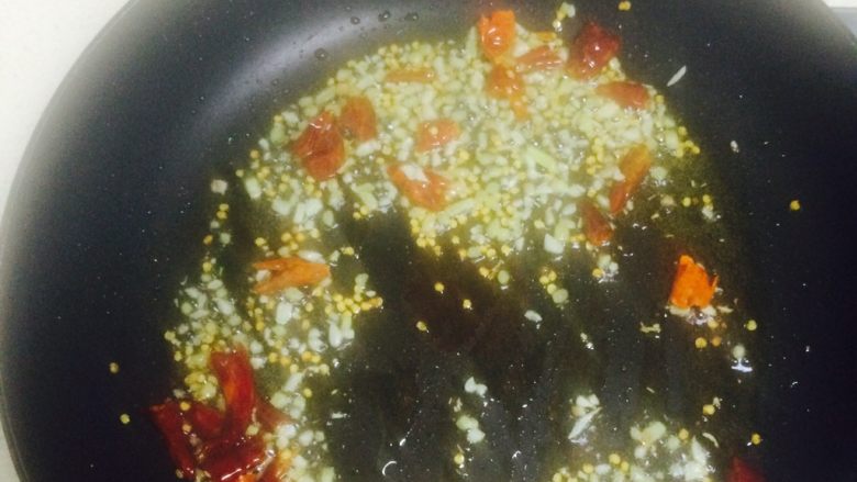蒜苔肉丝,在锅中倒入姜蒜末和干辣椒，小火炒出香味。