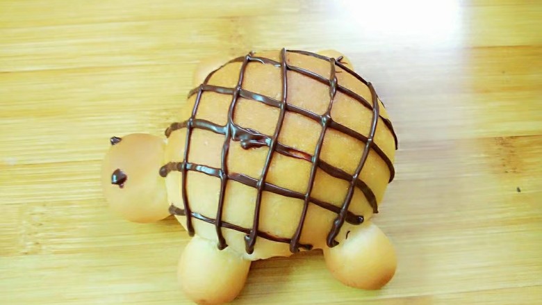 
小乌龟面包,巧克力装入裱花袋隔水融化，剪个小口，在乌龟的背上挤上网格状，点上眼睛，可爱的乌龟就完成了。