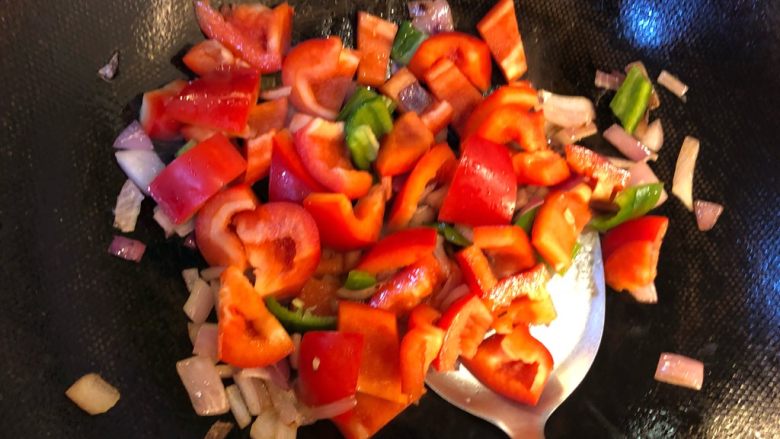 彩椒炒牛肉粒,洋葱炒软后加入彩椒翻炒，放入少许盐。