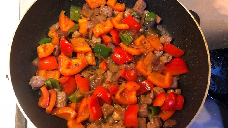 彩椒炒牛肉粒,牛肉回锅，和彩椒一起翻炒片刻。