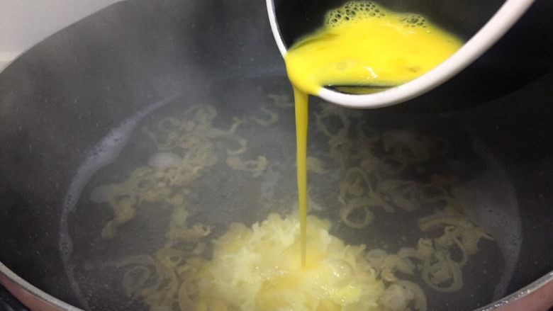 早餐系列之干贝边鸡蛋面,将鸡蛋打散，快速倒入锅中，用筷子在锅里快速搅拌