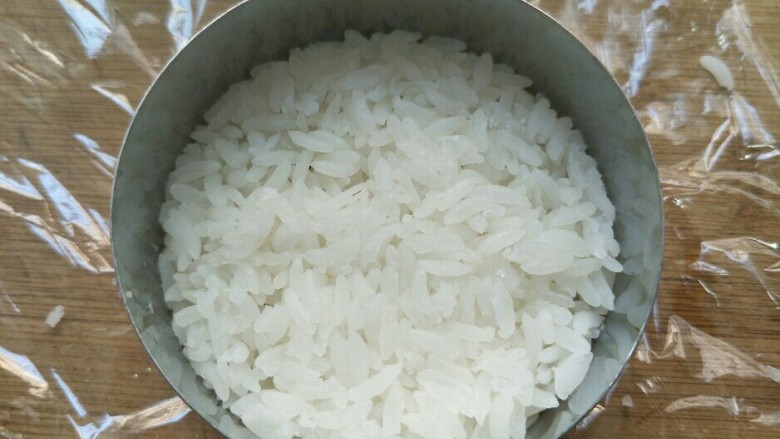 米饭猪肉堡,用勺子挖一勺米放入模具中压结实压平整。