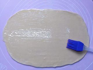 葱油饼,面团饧发好后，取一个饼的量，用擀面杖擀开，然后在上面刷一层薄薄的油。