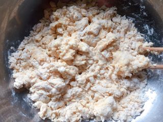葱油饼,打入一个鸡蛋，添加适量水，边加边用筷子搅拌成絮状。