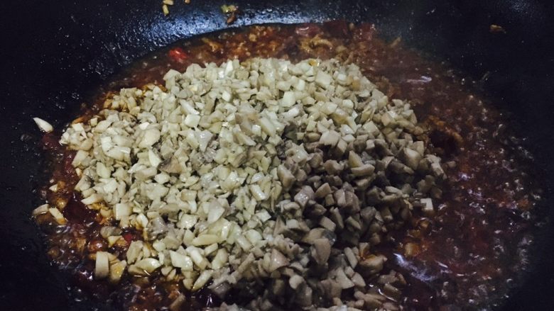 口蘑辣酱,放入口蘑，翻炒均匀。
不停的翻炒，尽可能把水分炒干。