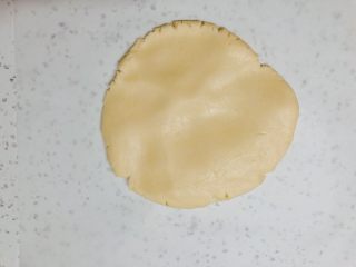 超平整口感佳的糖霜饼干底,台面垫一张油纸，把饼干面团放在上面，先用手掌按平一些。