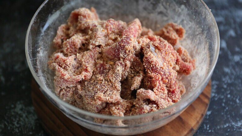 粉蒸牛肉,加入打好的米粉，用手充分抓拌均匀，将米粉裹满牛肉片；