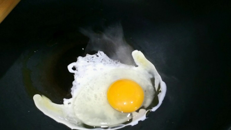 炒平菇,腌肉的期间，热油下鸡蛋煎，待鸡蛋底部成型后用铲子把蛋黄捣碎，把鸡蛋煎香。