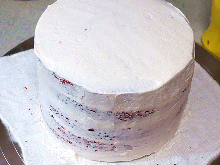 极简风。红丝绒生日蛋糕,蛋糕抹面。在蛋糕表面薄薄的抹上一层奶油霜