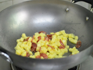土豆腊肠焖饭,锅里烧热油，依次放入腊肠、土豆拌炒