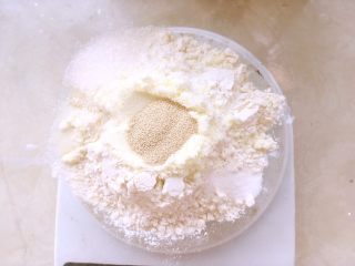 椰蓉小餐包,先来揉面团，将高筋面粉跟低筋面粉倒入容器内，加入奶粉、砂糖、盐、酵母，砂糖、盐跟酵母分开放