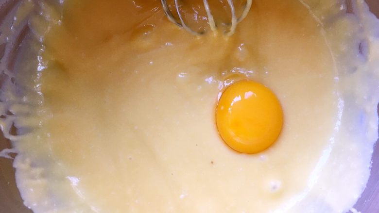 日式棉花蛋糕,分离鸡蛋，将蛋清打至干净容器，蛋黄一个一个的加入到面糊中，画Z字搅拌均匀，加入一个蛋黄搅拌均匀后再加入第二个跟第三个