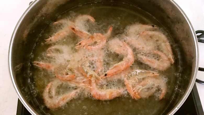 椒盐基围虾,锅里加入大豆色拉油，烧至5分热的时候加入基围虾温火炸制3分钟