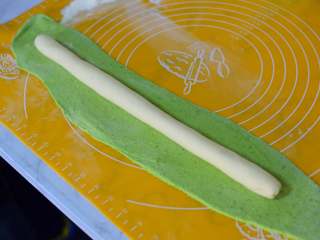 百财饺子,将白色面团放在绿色面片上。