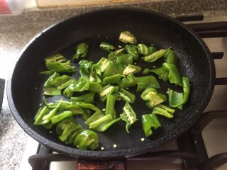 厨房挑战／荤菜／尖椒炒腊肉,先干炒辣椒，炒软倒入盘中。