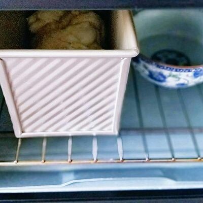 椰蓉吐司面包,放入烤箱进行二次发酵，天冷放一碗开水，天气较冷，中途水冷了可以换两次水。