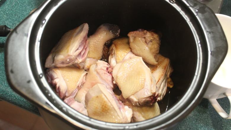 梅子鸡,将煎好的鸡肉摆入炖锅。