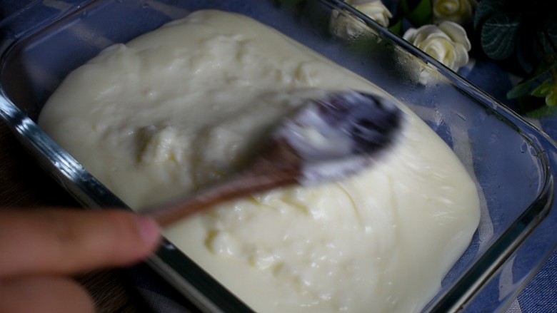 椰丝牛奶小方,用勺子稍稍整形，尽量涂抹平整