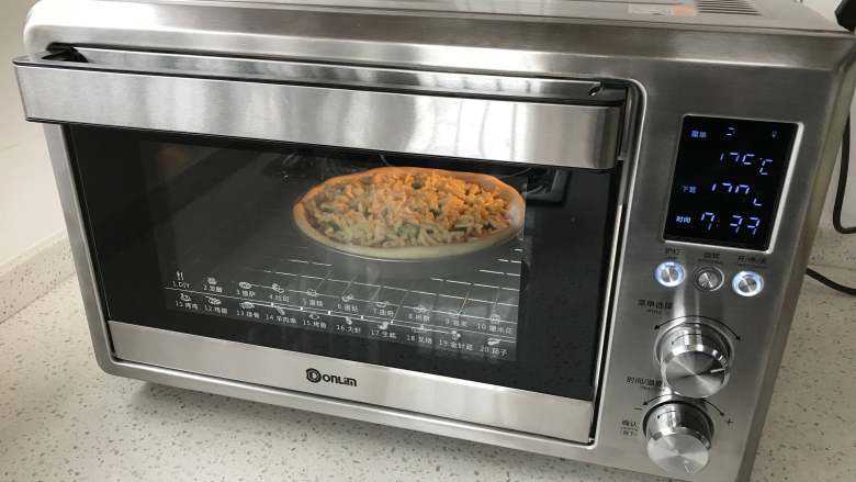 秋葵肉肠披萨,放入东菱岩烤烤箱，选择披萨模式，烘烤30分钟左右。